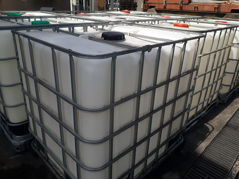 The IBC Container is located outside to be filled with liquid material from the isotank truck