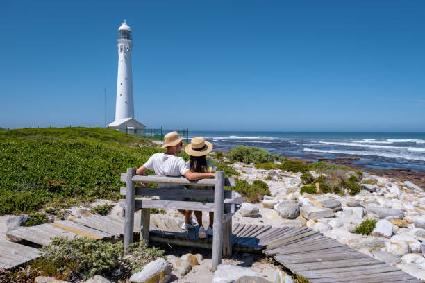 casal homem e mulher visitando o farol de slangkop kommetjie cape town south africa, o farol de slangkop na vila de kommetjie na península da cidade do cabo - slangkop - fotografias e filmes do acervo