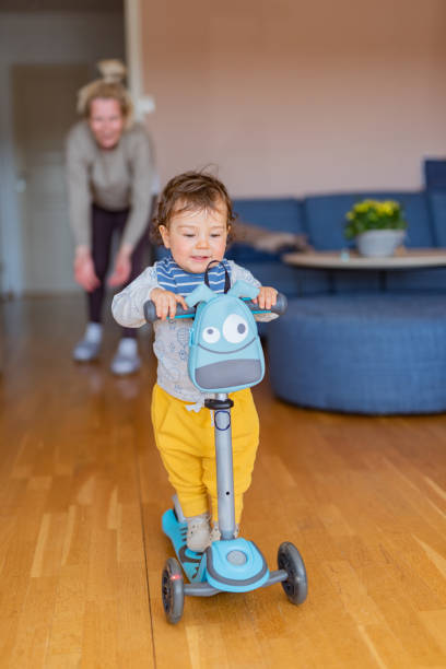 istock Boy riding scooter whit his mother at home 1373109774