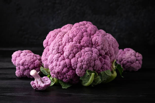 istock Purple colourful cauliflower on black wooden table 1373110600