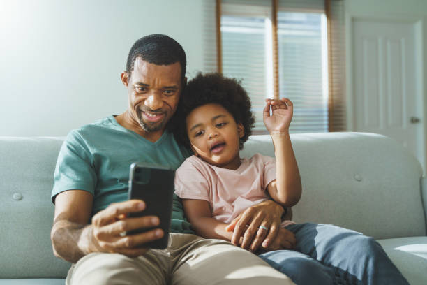 istock Smiling African American father and his cute boy taking selfies. 1373111702