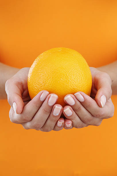 istock orange in woman hands 137311258
