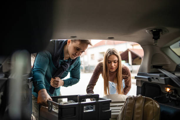 We're ready for the road A young couple is getting ready to travel, packing things into their car trunk furniture stock pictures, royalty-free photos & images