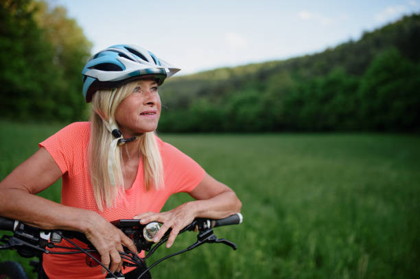 istock Cheerful active senior woman biker outdoors in nature. 1373114464