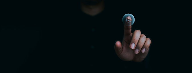 Icono azul de escaneo de huellas dactilares en la pantalla virtual mientras se escanea con los dedos el acceso de seguridad con identificación biométrica en la oscuridad. Ciberseguridad, tecnología de protección de datos de privacidad para empresas. photo