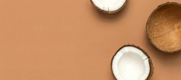 istock Creative layout with coconuts. Whole and half coconut on brown background. Minimal flat lay style, top view copy space. Food concept. Tropical exotic fruit, summer golden background 1373116917