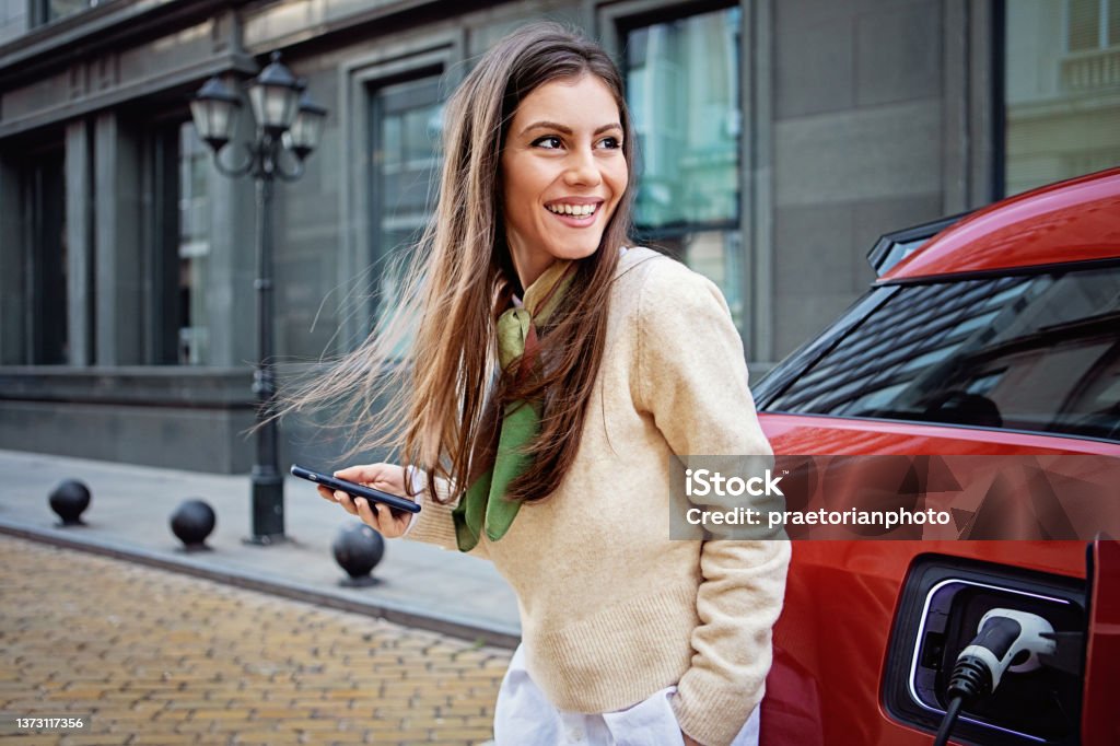 Portrait of woman charging her electric car - Royalty-free Araba - Motorlu Taşıt Stok görsel