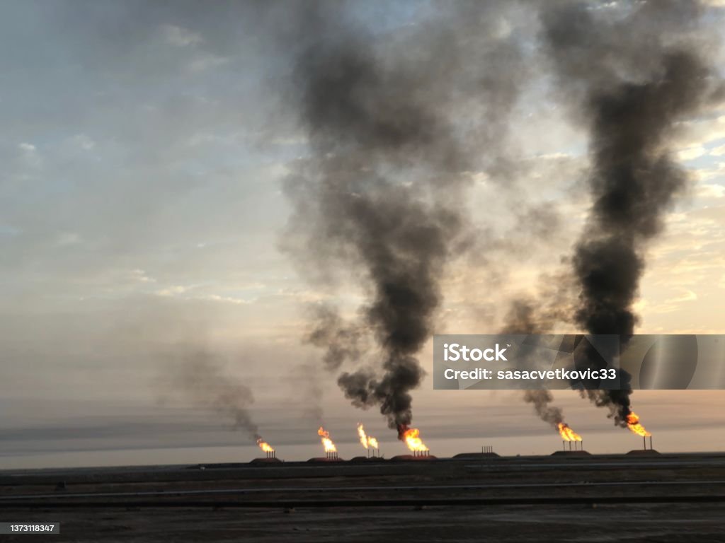 Air pollution, black smoke coming out of the chimney Oil fields in Iraq, pressure relief system. Oil preparation and pumping workshop Oil Field Stock Photo