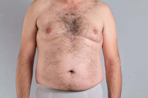 Fat hairy belly of a caucasian man isolated on grey background, no faces are shown, naked person Fat hairy belly of a caucasian man isolated on grey background, no faces are shown hairy fat man pictures stock pictures, royalty-free photos & images