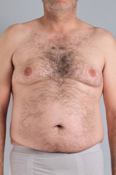 Fat hairy belly of a caucasian man isolated on grey background, no faces are shown, close up, nudity shown Fat hairy belly of a caucasian man isolated on grey background, no faces are shown, close up, nudity shown hairy fat man pictures stock pictures, royalty-free photos & images