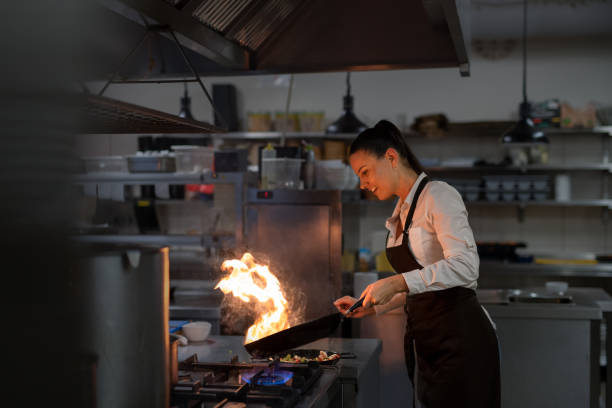 istock Professional chef preparing meal, flambing indoors in restaurant kitchen. 1373120966
