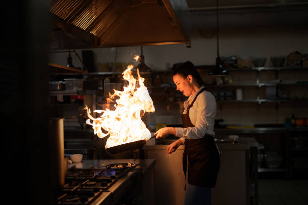 istock Professional chef preparing meal, flambing indoors in restaurant kitchen. 1373120975