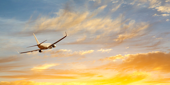 Airplane wing in the sky at beautiful sunset, airplane flight in the sky with copy space.