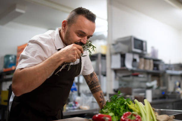 istock Mature chef smelling herbs in commercial kitchen. 1373121171