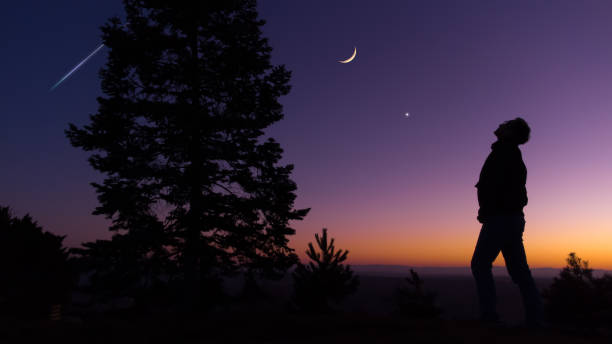 istock Man observing evening sky with stars, planets and crescent Moon. 1373124342