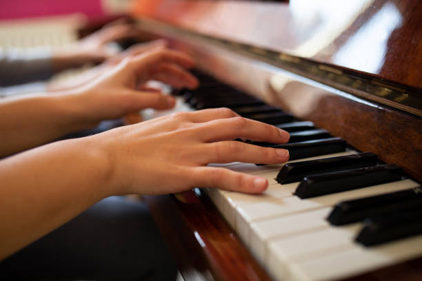 istock Teacher and student playing together piano 1373124480