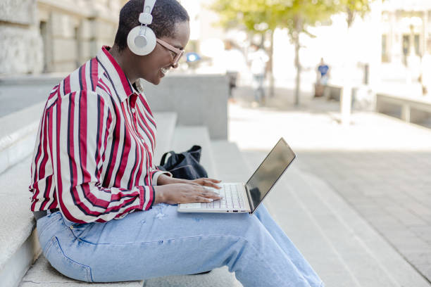 istock Young woman using laptop in front of the University 1373127404