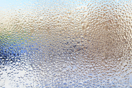 Frozen drops on glass. Condensate. Freezing rain. Close-up. Background. Texture.