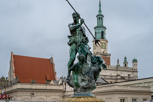 The Neptune Fountain on the Main Market (Rynek) square in the Old Town of Poznan, Poland. The city hall tower in the background