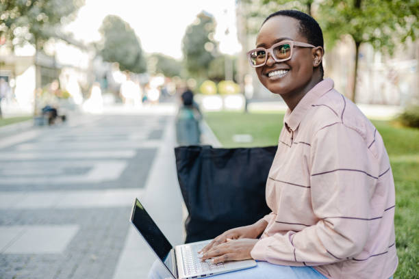 istock Young woman using laptop outdoors 1373128182