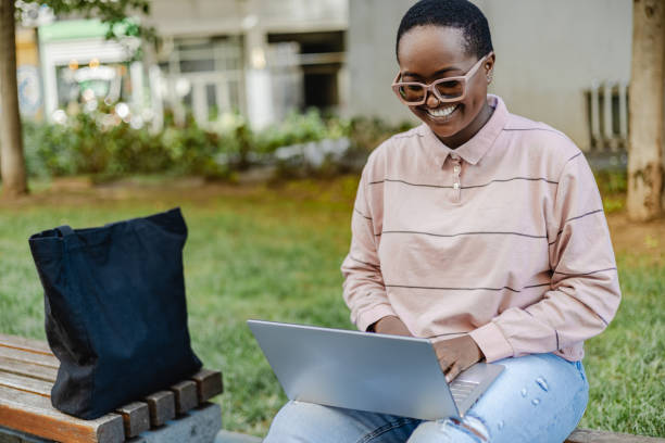 istock Young woman using laptop outdoors 1373128202