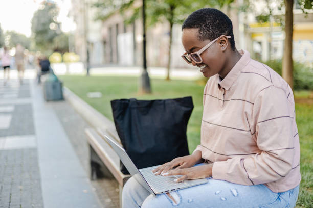 istock Young woman using laptop outdoors 1373128203
