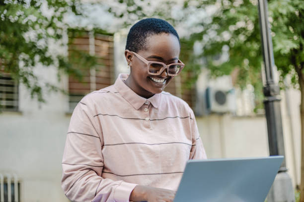 istock Young woman using laptop outdoors 1373128325