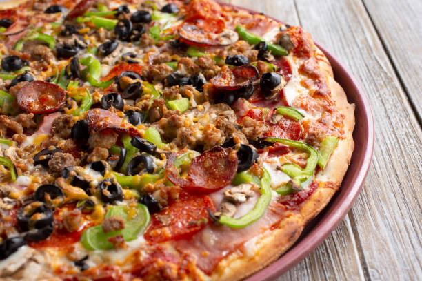 meat and veggie pizza pie stock photo