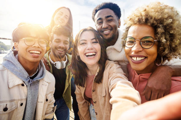 istock Happy young friends having fun while taking a selfie with mobile phone outdoors 1373129835