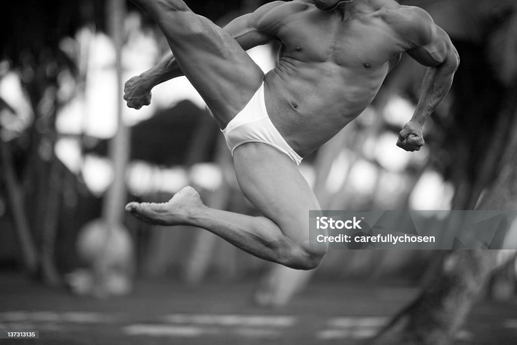 airborne athlete jumps A muscular kick boxer is caught mid flight as he shows off his martial arts skill and awesome body. Shallow DOF and natural background. Unshapened. Please rate if you have the time. Eos5D. Judo Stock Photo