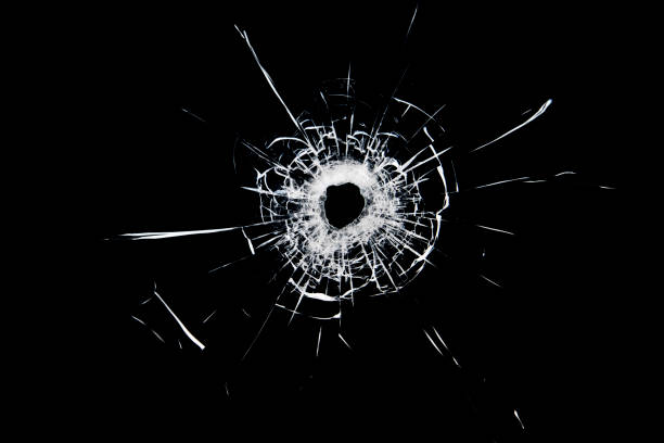 textura de vidrio roto. agujero de una bola sobre fondo negro. - bullet bullet hole hole glass fotografías e imágenes de stock