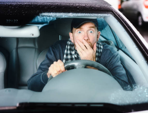perigo à frente: motorista de olhos arregalados leva um susto terrível enquanto dirige seu carro - shower human face men wet - fotografias e filmes do acervo