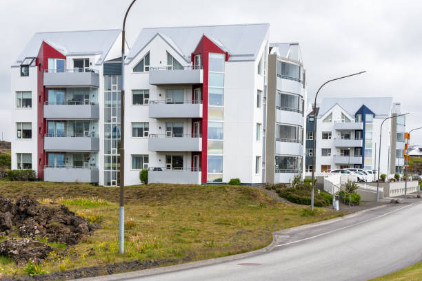 Modern four-storey apartment building along a street on a cloudy day. Reykjavik, Iceland.