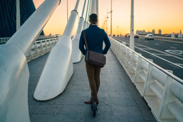Businessman riding scooter at evening
