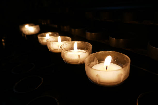 Row with prayer tea lights in a roman catholic church. The candles are lighted to underline a prayer