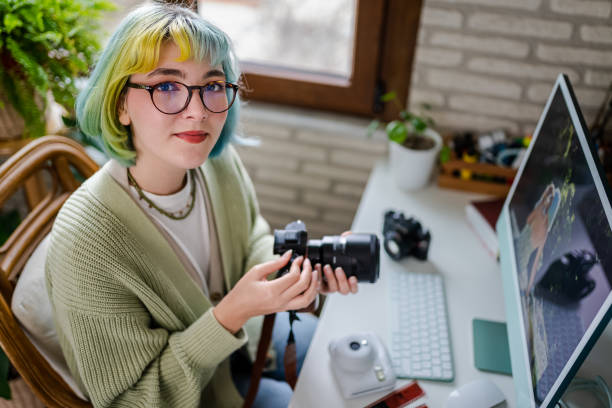 Millennial photographer working on her photos at home office stock photo