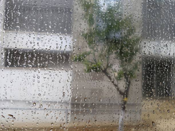 istock Raindrops on glass window. Blurry street view from rainy day window with water drops. 1373148378