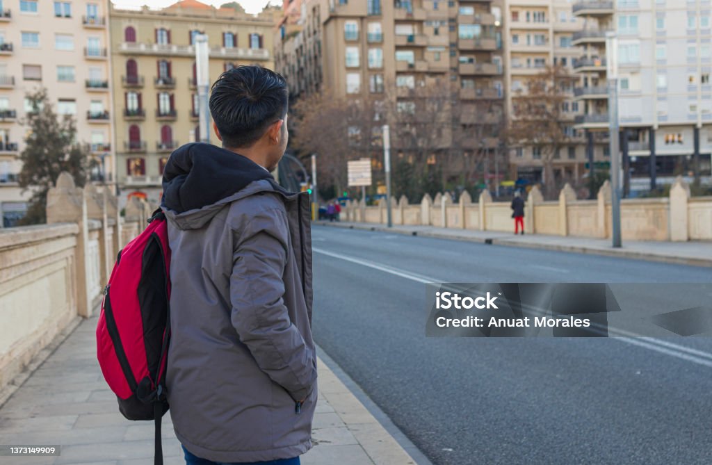 back view of a mexican exchange student standing on a bridge back view shot of a mexican exchange student with backpack standing on a bridge looking something Exchange Student Stock Photo