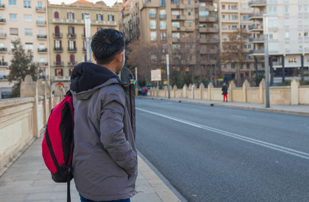 back view of a mexican exchange student standing on a bridge back view shot of a mexican exchange student with backpack standing on a bridge looking something walking point of view stock pictures, royalty-free photos & images