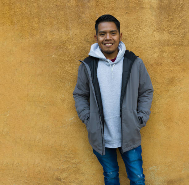 istock A mexican ethnicity animated man smiling while is standing ahead of a yellow wall. 1373149973