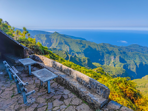 Mountain benches on the footpath to Pico Ruivo peak in Madeira island for short rest with amazing view and clouds below.