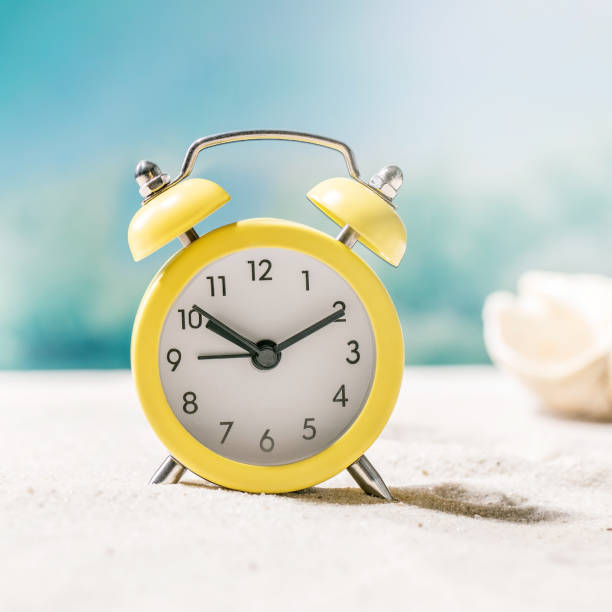 istock Summer sand sea beach with waves and alarm clock 1373152370