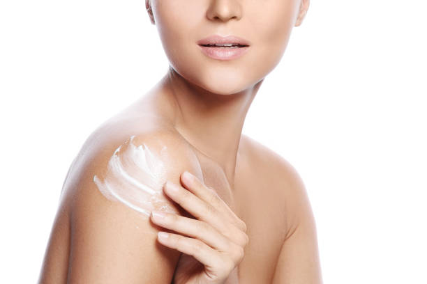istock Young and beautiful woman with applying moisturizing cream on her shoulder 1373153806