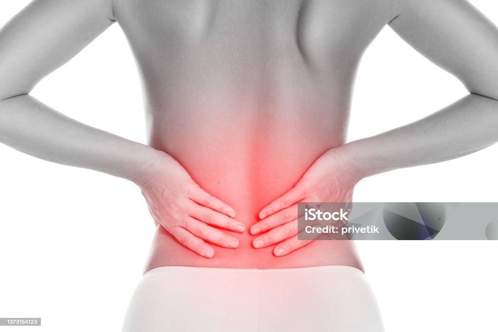Young woman suffering from lower back pain Young woman suffering from lower back pain on white background Women Stock Photo