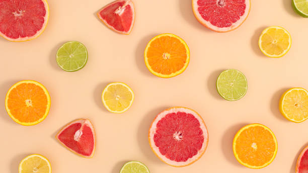 istock Summer pattern with sliced fresh various citrus fruits on pastel beige background. Flat lay creative tropic composition 1373154270