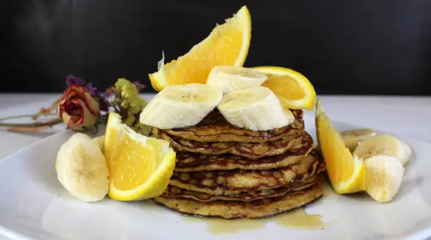 Oatmeal, banana and orange pancakes! Dipped in honey, fresh banana slices and fresh orange slices! Delicious, nutritious!!