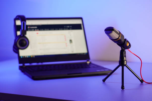 istock Microphone, laptop and headphones for home studio podcast session over blue background. Blogging and live streaming concept. 1373155288
