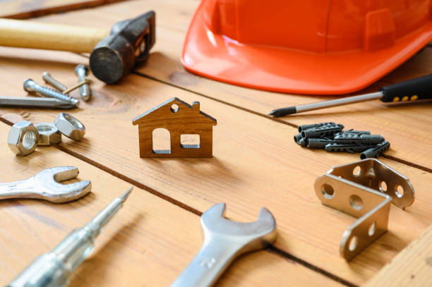 istock Construction tools and a hard hat lie around a small figurine of a house on a wooden table. Selective focus on the house. The concept of construction and repair. 1373156452