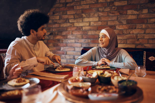 istock Young Muslim couple talking while having meal on Iftar during Ramadan. 1373157842