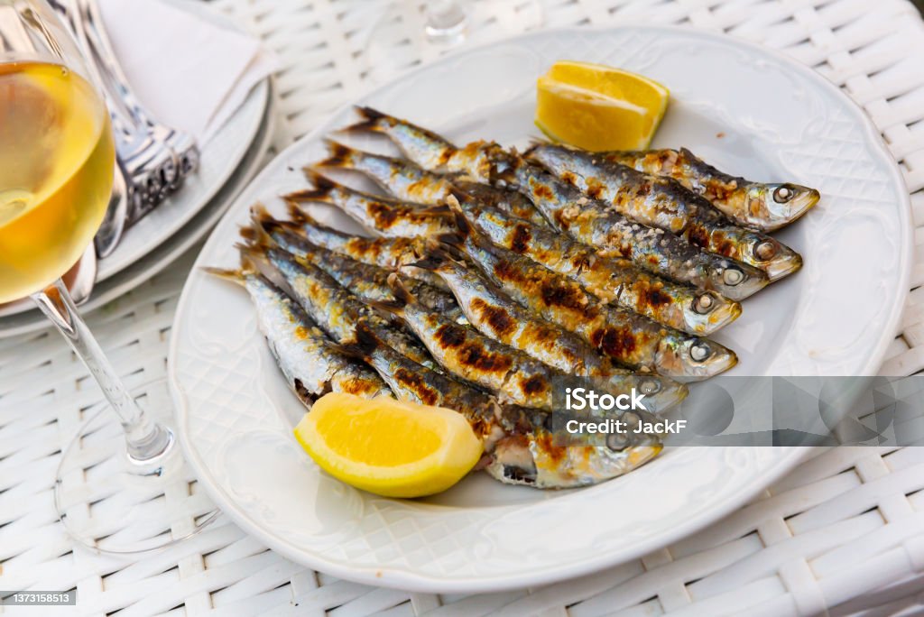 Espeto de sardinas with slice of lemon Portion of charcoal grilled sardines served with lemon, typical seafood appetizer of Malaga, Spain Sardine Stock Photo